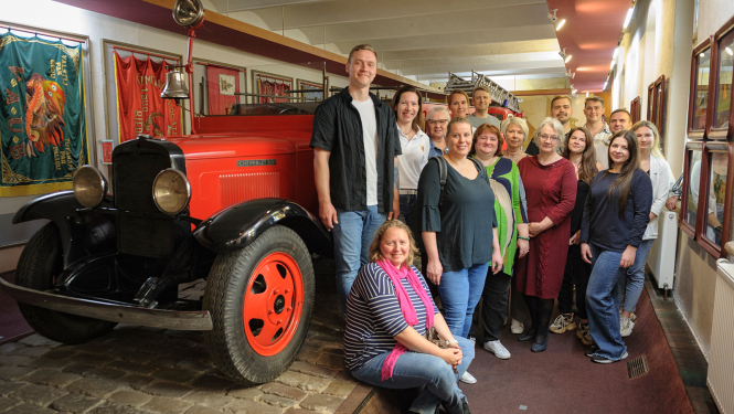 Pārvaldes kolektīvs Vēstures zēlē pie ugunsdzēsības automašīnas